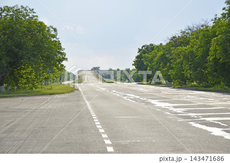 The asphalt road goes into the distance and ends with an ascent to a bridge The asphalt road goes into the distance and ends with an ascent to a bridge 143471686