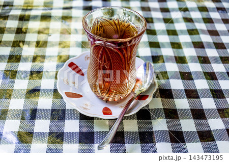 Black tea herbal Turkish glass mug armud stands on table coffee shop restaurant 143473195