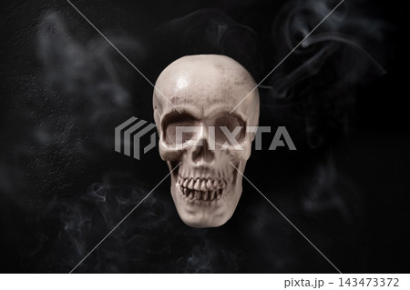 Scary human skull with smoke on black background for Halloween Scary human skull with smoke on black background for Halloween 143473372