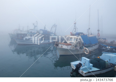 Fishing boats in the foggy harbor of Jaffa port. Israel 143473766