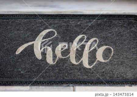 black doormat with white hello text 143473814