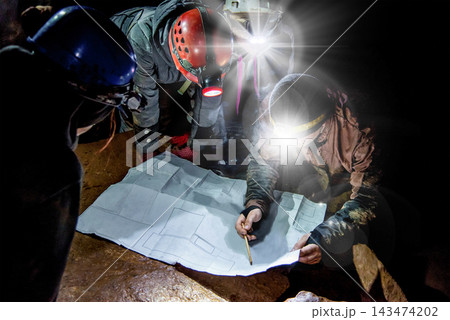 Speleologist explores an underground cave, geologist studies hole rock mountain Speleologist explores an underground cave, geologist studies hole rock mountain 143474202