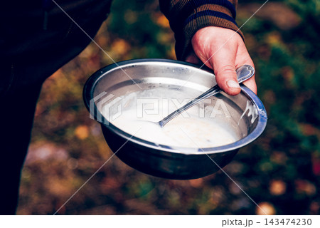 Tourist cooking camping food picnic on campfire kitchen, man holds metal plate Tourist cooking camping food picnic on campfire kitchen, man holds metal plate 143474230