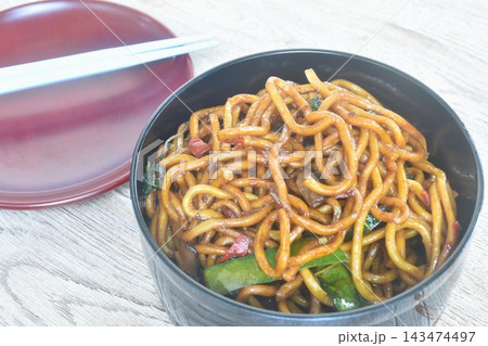 fried yakisoba Japanese noodles with green pea and cabbage in spicy sauce in lunch box  143474497