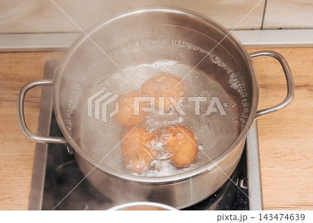 Brown chicken eggs boiled metal pots on stove kitchen, cooking healthy breakfast Brown chicken eggs boiled metal pots on stove kitchen, cooking healthy breakfast 143474639