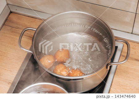 Brown chicken eggs boiled metal pots on stove kitchen, cooking healthy breakfast Brown chicken eggs boiled metal pots on stove kitchen, cooking healthy breakfast 143474640