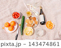 Countryside picnic summer weekend, wine, fruits and vegetables on rustic blanket 143474861