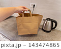 Hand lifting takeaway delivery paper bag during household organization kitchen 143474865