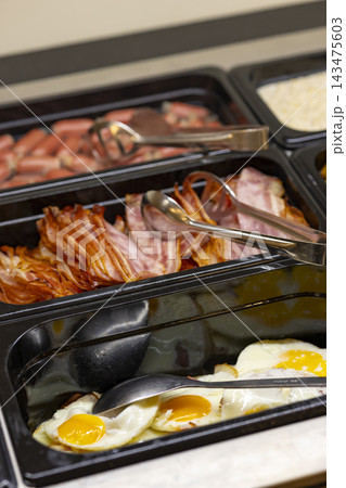 Hotel buffet serving bacon, eggs, and sausages Hotel buffet serving bacon, eggs, and sausages 143475603