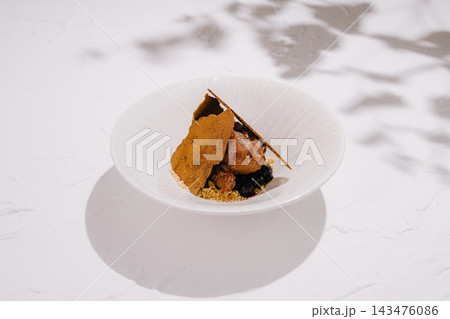 Gourmet chocolate mousse dessert with berry and crumble 143476086