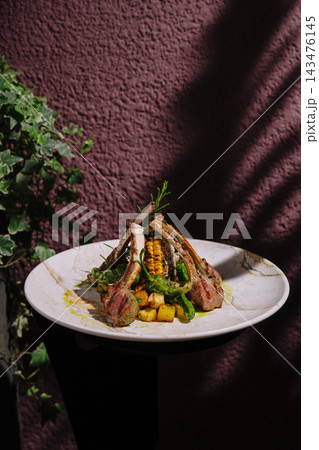 Grilled lamb chops with corn, potatoes, and rosemary on a plate Grilled lamb chops with corn, potatoes, and rosemary on a plate 143476145
