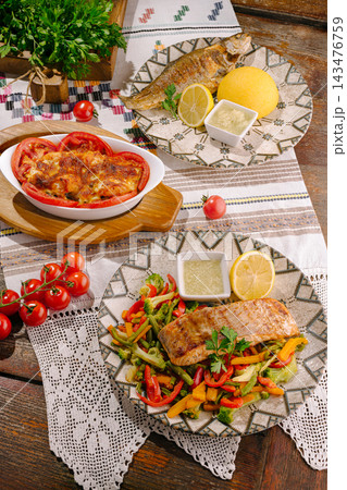 Grilled fish, salmon fillet, and vegetables on rustic table Grilled fish, salmon fillet, and vegetables on rustic table 143476759