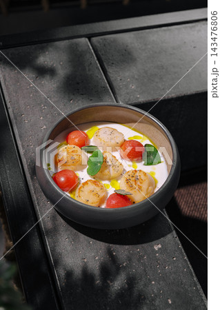 Seared scallops with creamy sauce and cherry tomatoes 143476806