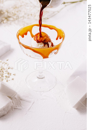 Pouring espresso coffee onto vanilla ice cream affogato 143477025