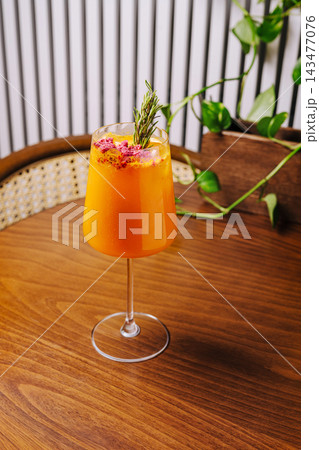 Refreshing orange cocktail with rosemary and dried raspberries Refreshing orange cocktail with rosemary and dried raspberries 143477076