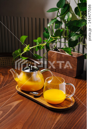 Sea buckthorn tea serving on wooden tray at home 143477086