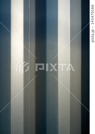 Close-up of vertical metal window bars with blue-gray reflections, modern industrial facade detail for architecture, privacy and design concepts now filled with light shadows Close-up of vertical metal window bars with blue-gray reflections, modern industrial facade detail for architecture, privacy and design concepts now filled with light shadows 143479166