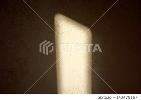 Close-up vertical illuminated panel on textured concrete wall with dramatic light and shadow, minimal abstract indoor background, warm tones in focus Close-up vertical illuminated panel on textured concrete wall with dramatic light and shadow, minimal abstract indoor background, warm tones in focus 143479167