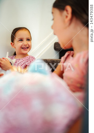 Young sisters laughing playing together on stairs at home Young sisters laughing playing together on stairs at home 143479388