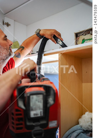 Man vacuuming dust during home renovation 143479389