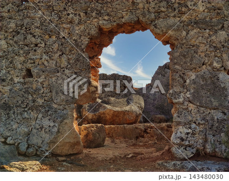 Ancient stone ruins with arched entrance opening to a bright blue sky. Ancient stone ruins with arched entrance opening to a bright blue sky. 143480030