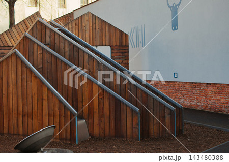 Modern wooden playground structures in a public city park. Modern wooden playground structures in a public city park. 143480388