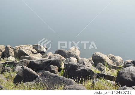 Rocks along the Selorejo Dam in Malang Regency. Ideal for nature, coastal, or geology themes. Rocks along the Selorejo Dam in Malang Regency. Ideal for nature, coastal, or geology themes. 143480735