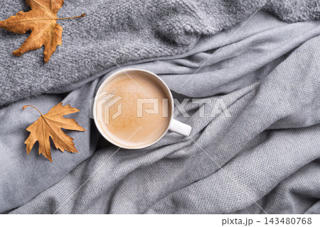Coffee hot drink and autumn maple leaves on soft grey knit texture 143480768
