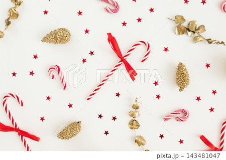 Candy canes, stars and ornaments arranged on white for a festive holiday background. Candy canes, stars and ornaments arranged on white for a festive holiday background. 143481047