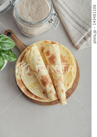 Stack of lavash or chapati flatbreads on a wooden cutting board Stack of lavash or chapati flatbreads on a wooden cutting board 143481108