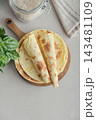 Stack of lavash or chapati flatbreads on a wooden cutting board 143481109