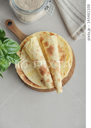 Stack of lavash or chapati flatbreads on a wooden cutting board Stack of lavash or chapati flatbreads on a wooden cutting board 143481109