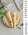 Stack of lavash or chapati flatbreads on a wooden cutting board 143481110