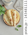 Stack of lavash or chapati flatbreads on a wooden cutting board 143481111
