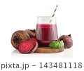 Beetroot juice in a glass with a striped paper straw, served with raw beetroot and fresh basil 143481118
