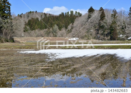 雪解けが進む田んぼと山間の風景 雪解けが進む田んぼと山間の風景 143482683
