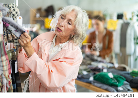 Mature woman customer examine and choose scarf in store 143484181