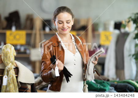 Young woman choosing gloves in clothing store 143484248
