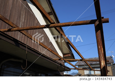 台風被害で屋根が飛ばされ骨組みだけ残った住宅の軒先。 143484743