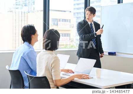 オフィスで講師から資産形成や投資の説明を受ける若い男女 オフィスで講師から資産形成や投資の説明を受ける若い男女 143485477