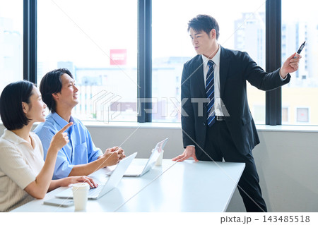オフィスで講師から資産形成や投資の説明を受ける若い男女 143485518