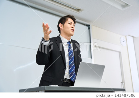 教室でパソコンを使いながら授業をする大学や専門学校の先生 教室でパソコンを使いながら授業をする大学や専門学校の先生 143487306