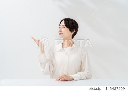 手を差し出して案内する笑顔の女性 手を差し出して案内する笑顔の女性 143487409