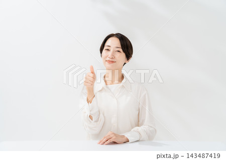 サムズアップをする笑顔の女性 143487419