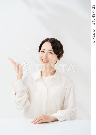 手のひらで案内する笑顔の女性 手のひらで案内する笑顔の女性 143487425