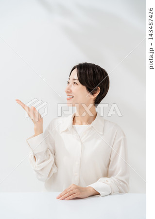 手を差し出して案内する笑顔の女性 手を差し出して案内する笑顔の女性 143487426