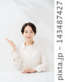 手のひらで案内する笑顔の女性 143487427
