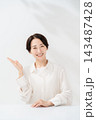 手のひらで案内する笑顔の女性 143487428
