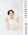 両手でサムズアップをする笑顔の女性 143487433