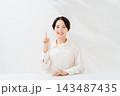 人差し指を立てて説明する笑顔の女性 143487435
